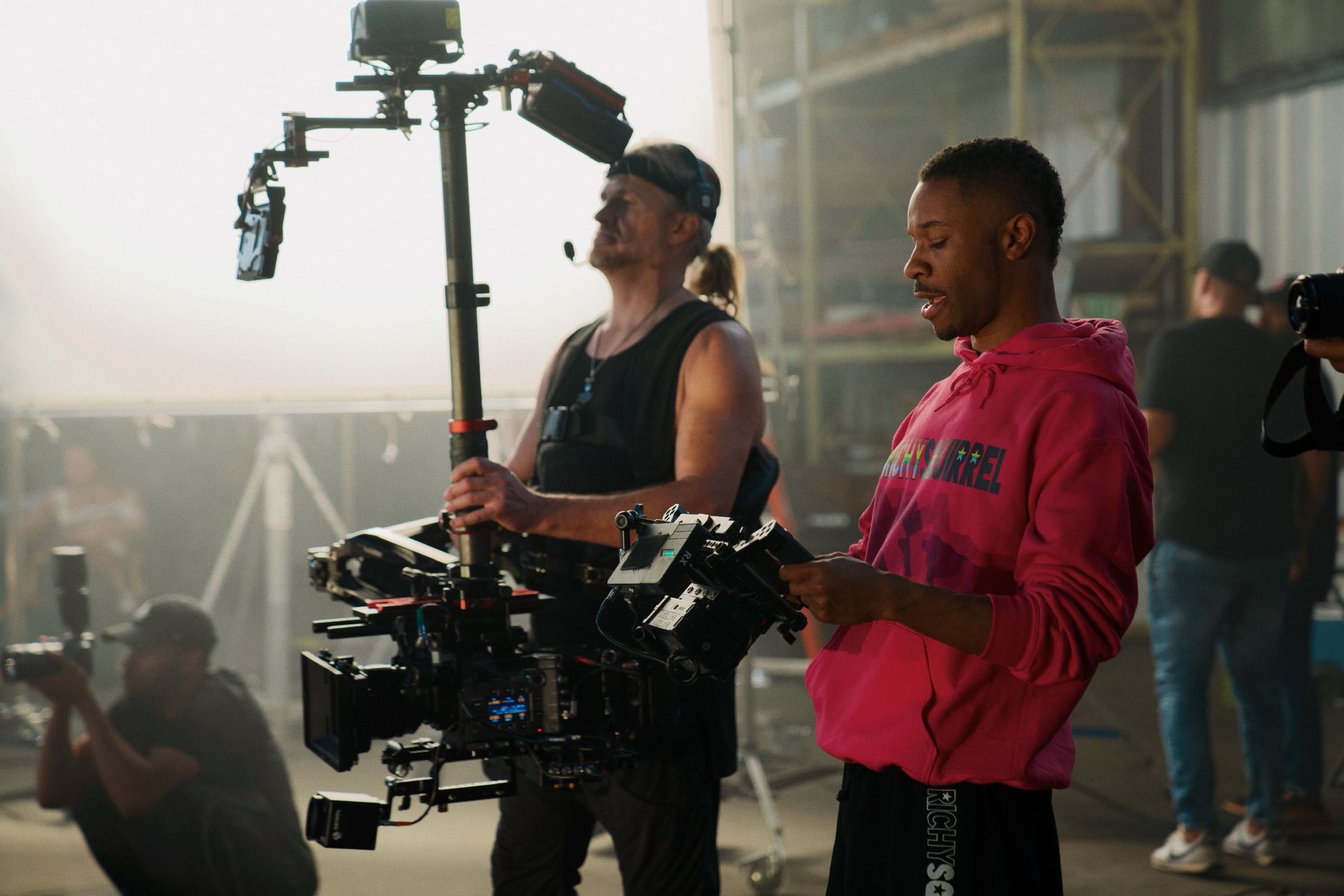 Camera operator and crew working through haze on a Good Feelin Studios set.