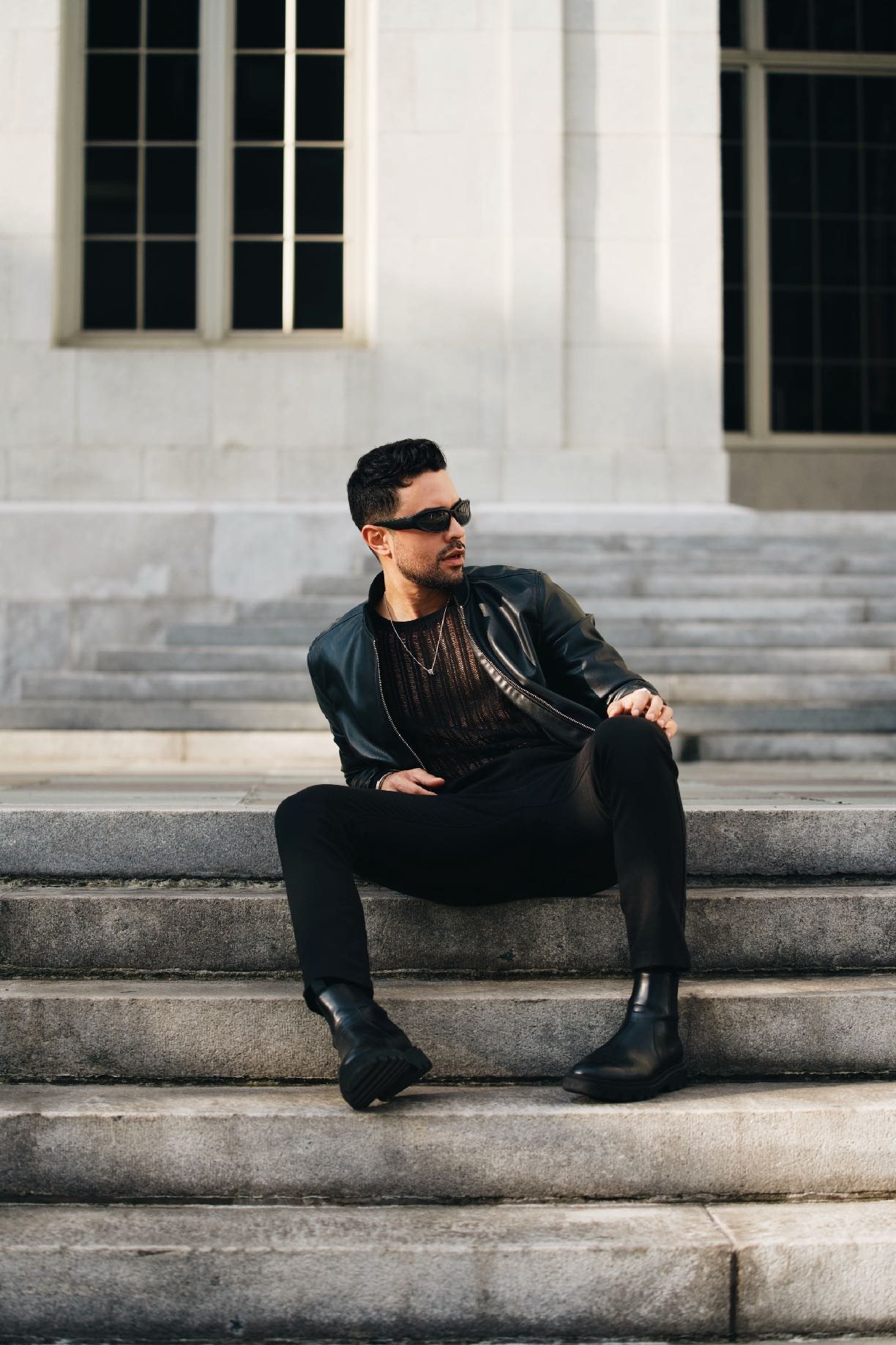 Figure in black seated on wide stone steps.